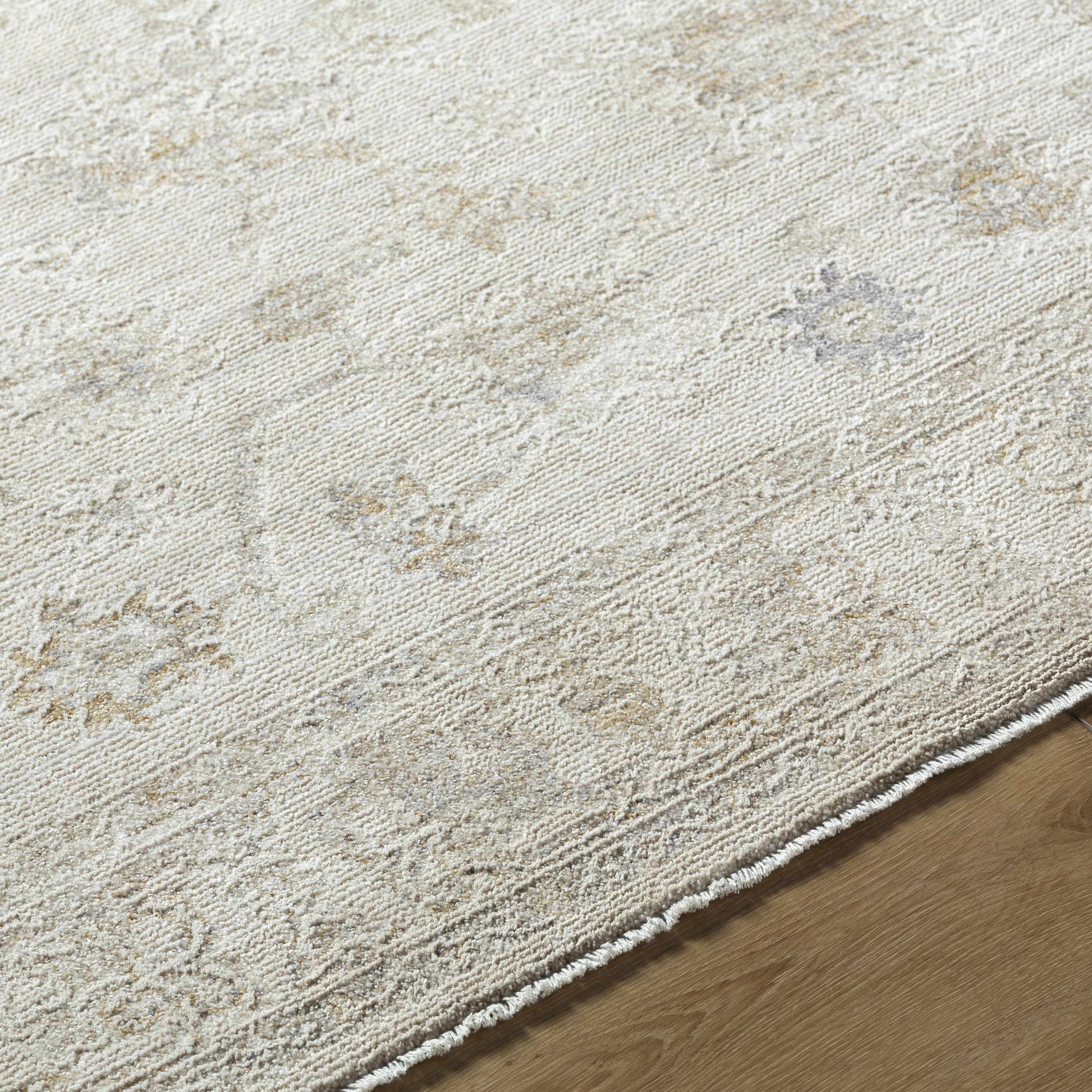 Close-up of a textured beige rug on a wooden floor