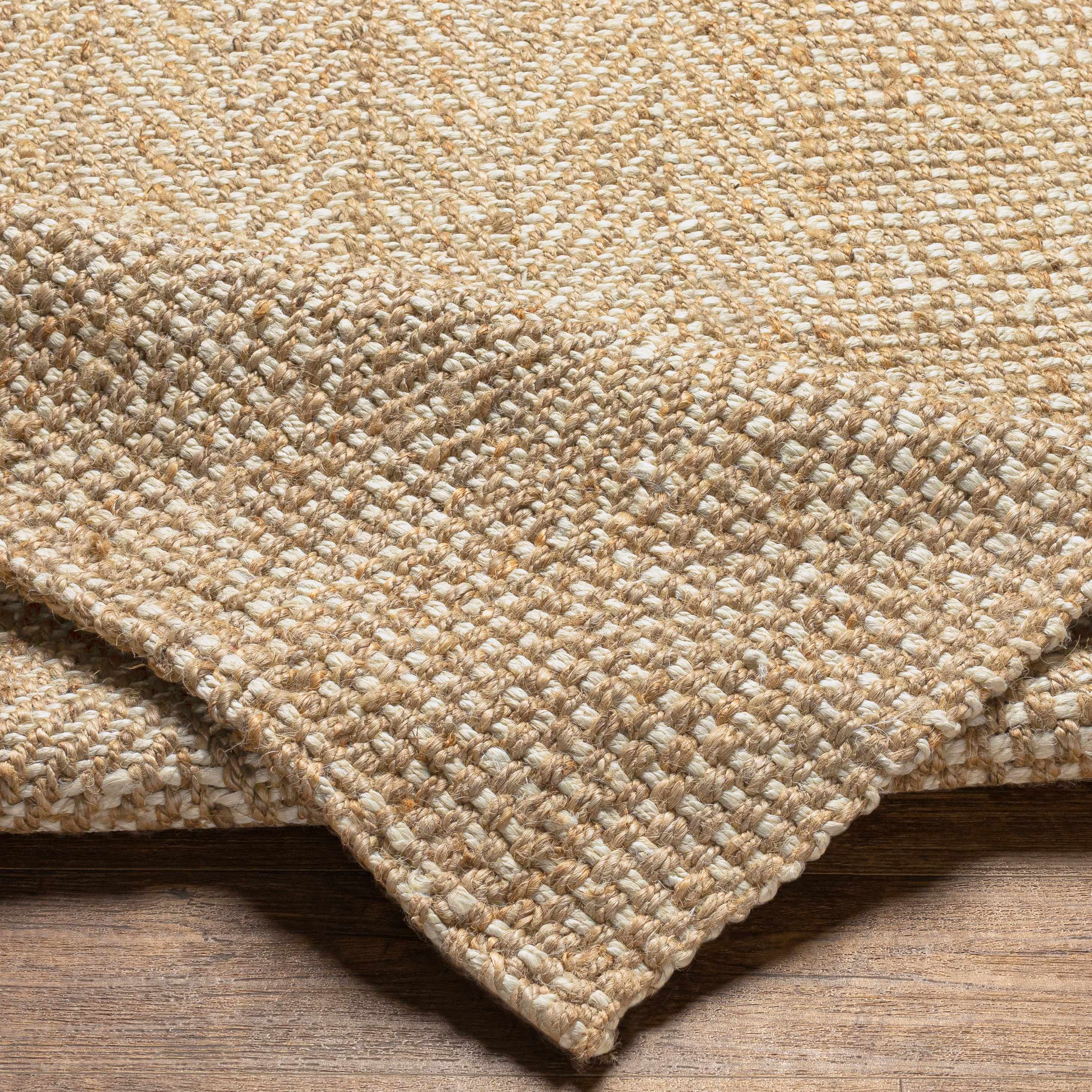 Close-up of a textured beige carpet on a wooden floor
