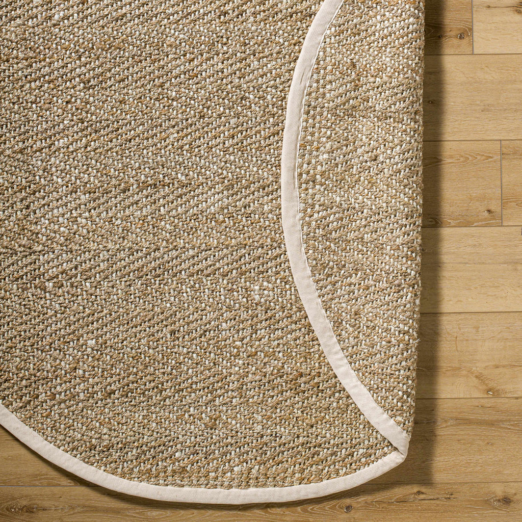 Beige woven rug with a white border on a wooden floor