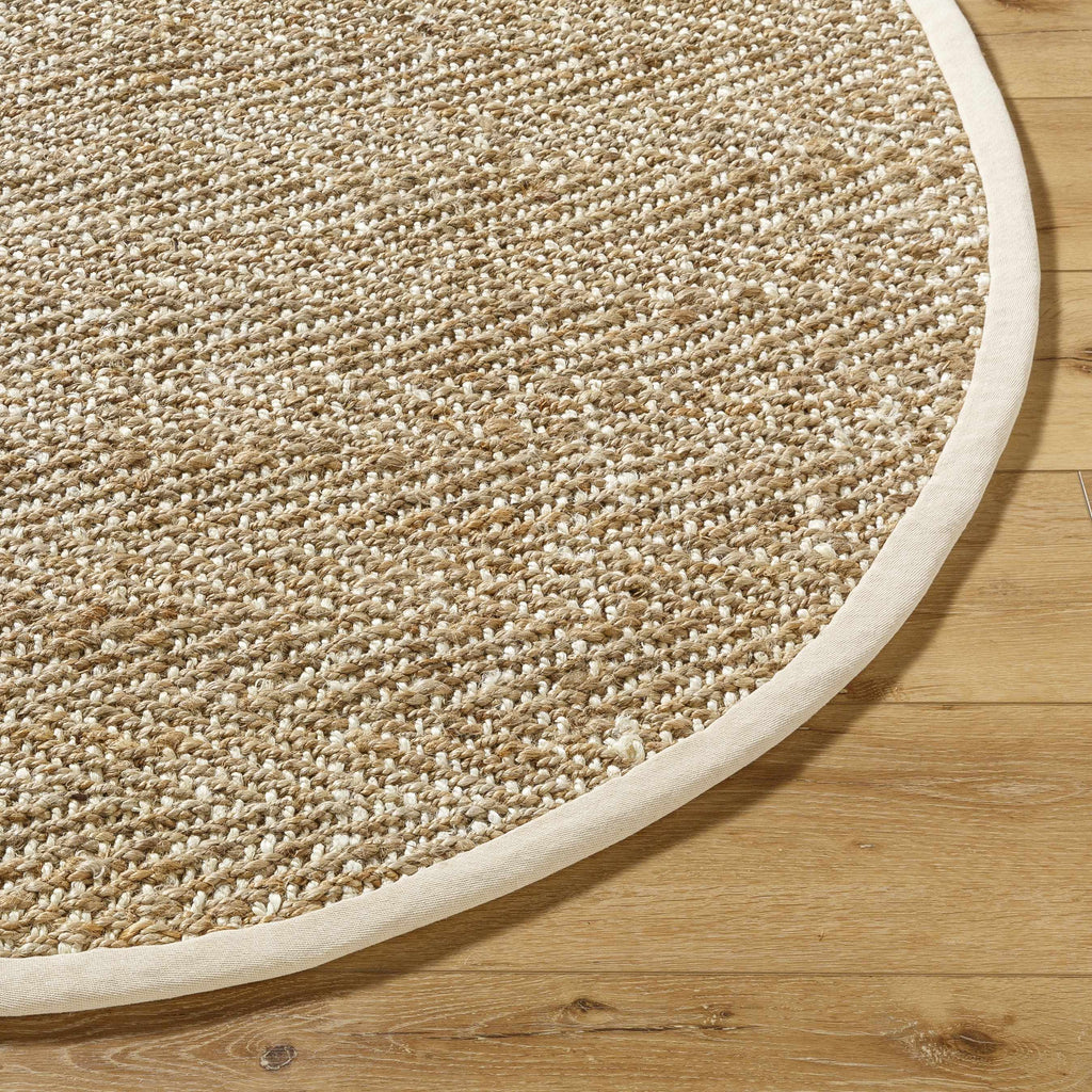 Round beige rug on a wooden floor