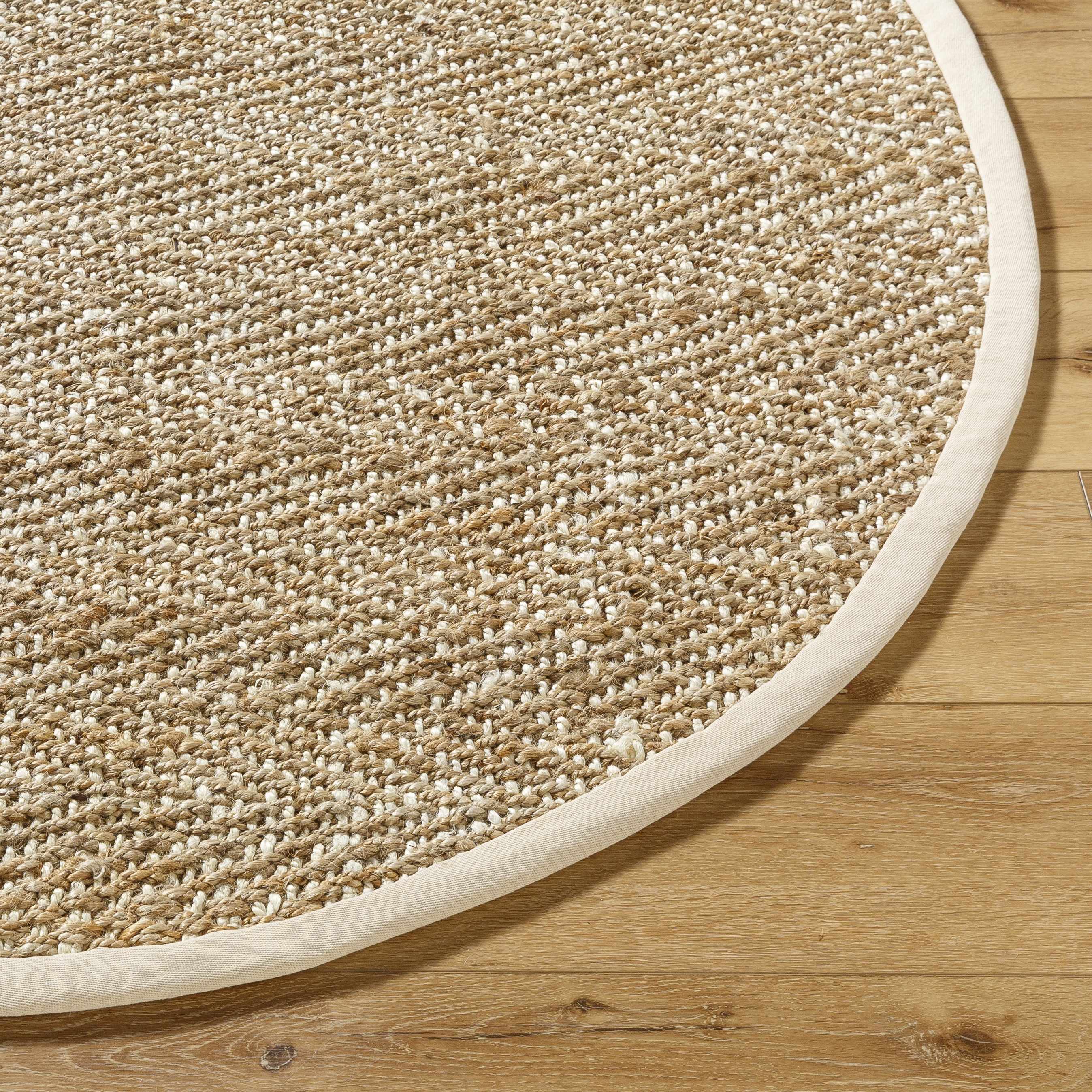 Round beige rug on a wooden floor