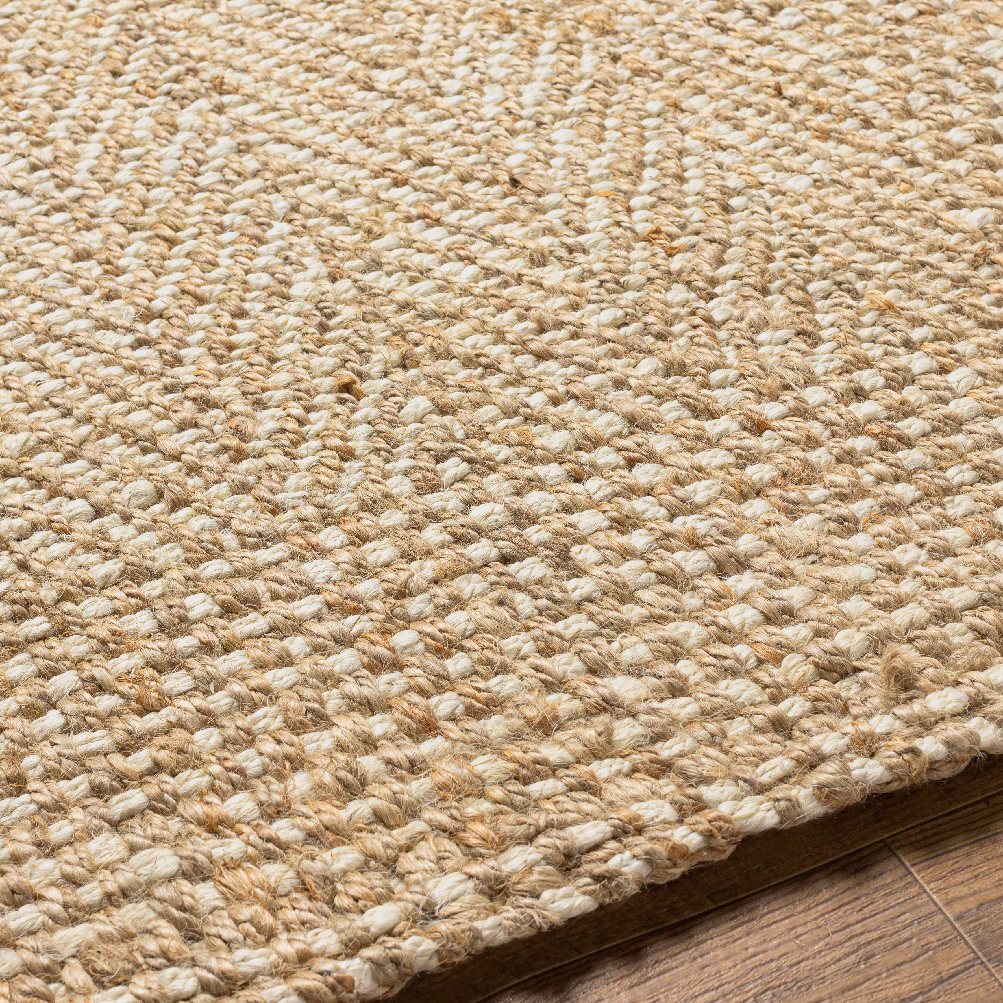 Close-up of a textured beige rug on a wooden floor