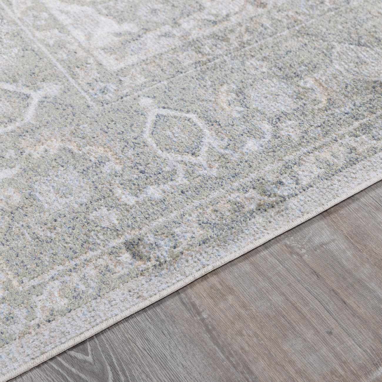 Close-up of a textured gray rug on a wooden floor