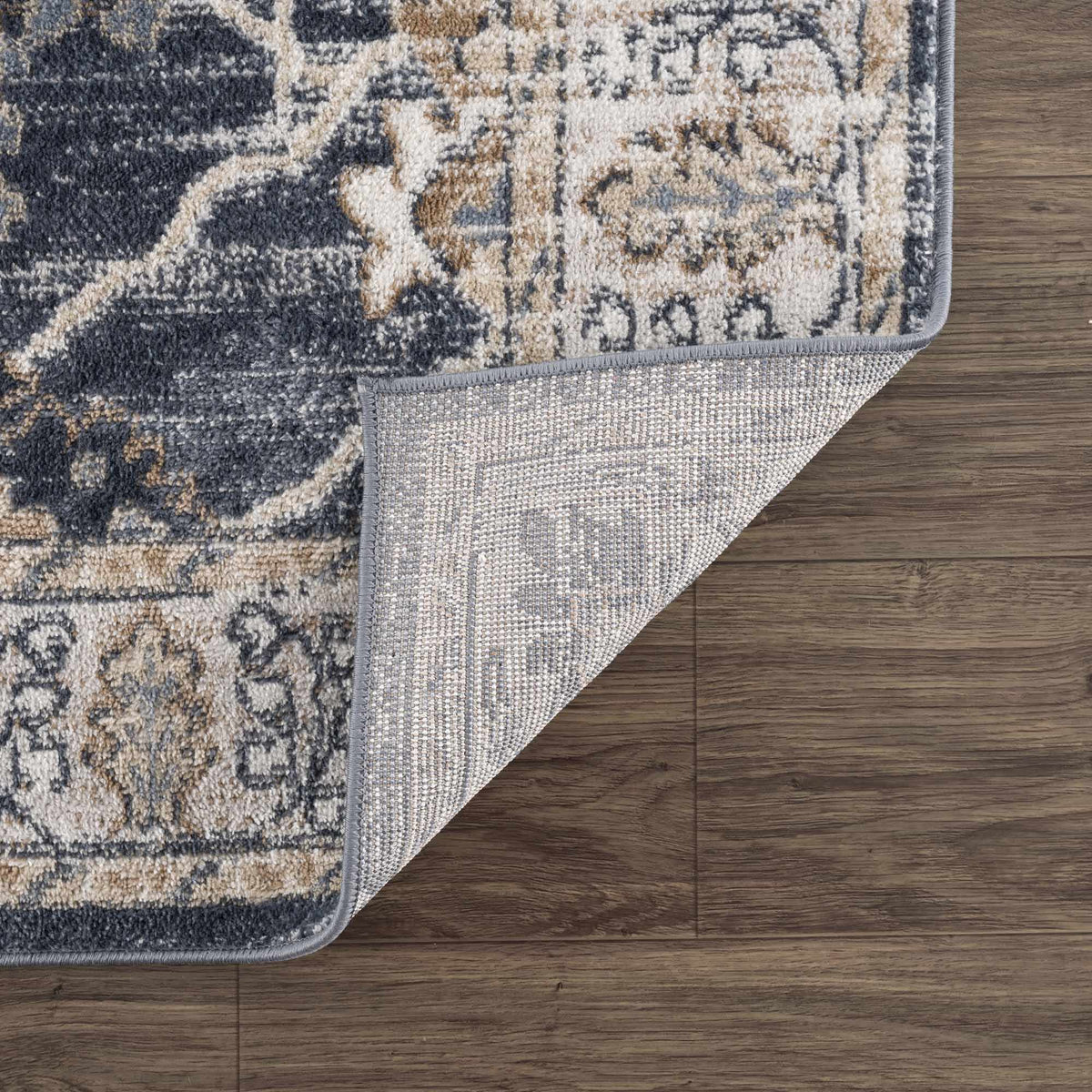 Patterned rug corner on a wooden floor