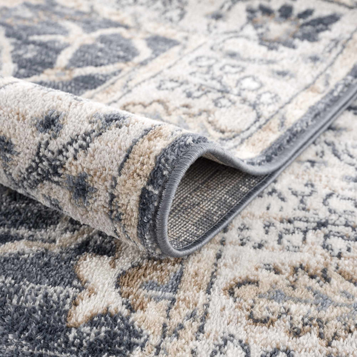 Close-up of a patterned rug being rolled up