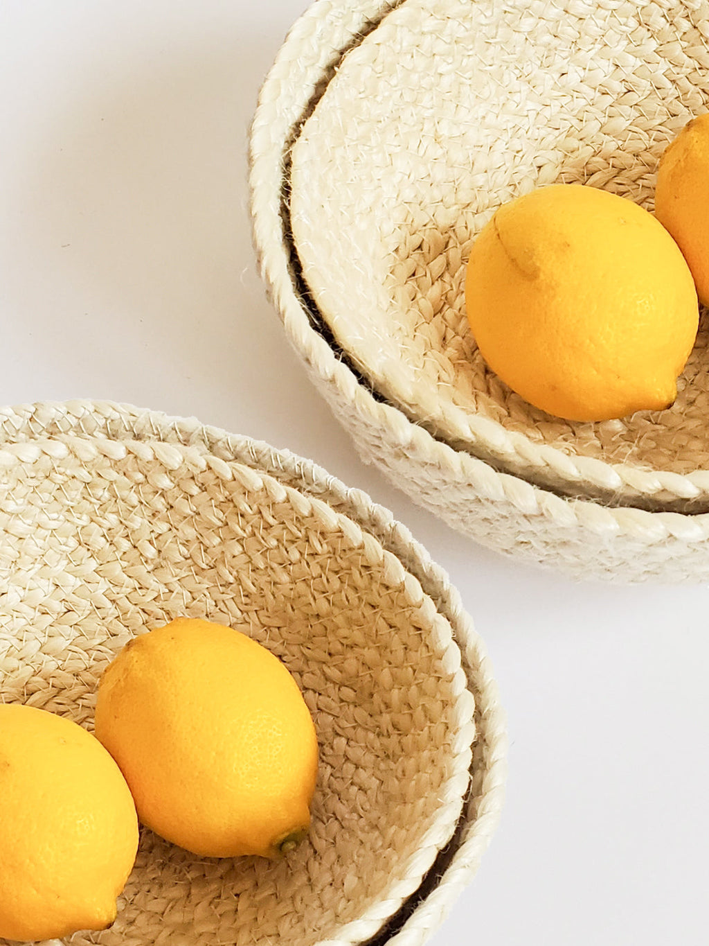 Two woven bowls with lemons on a light background