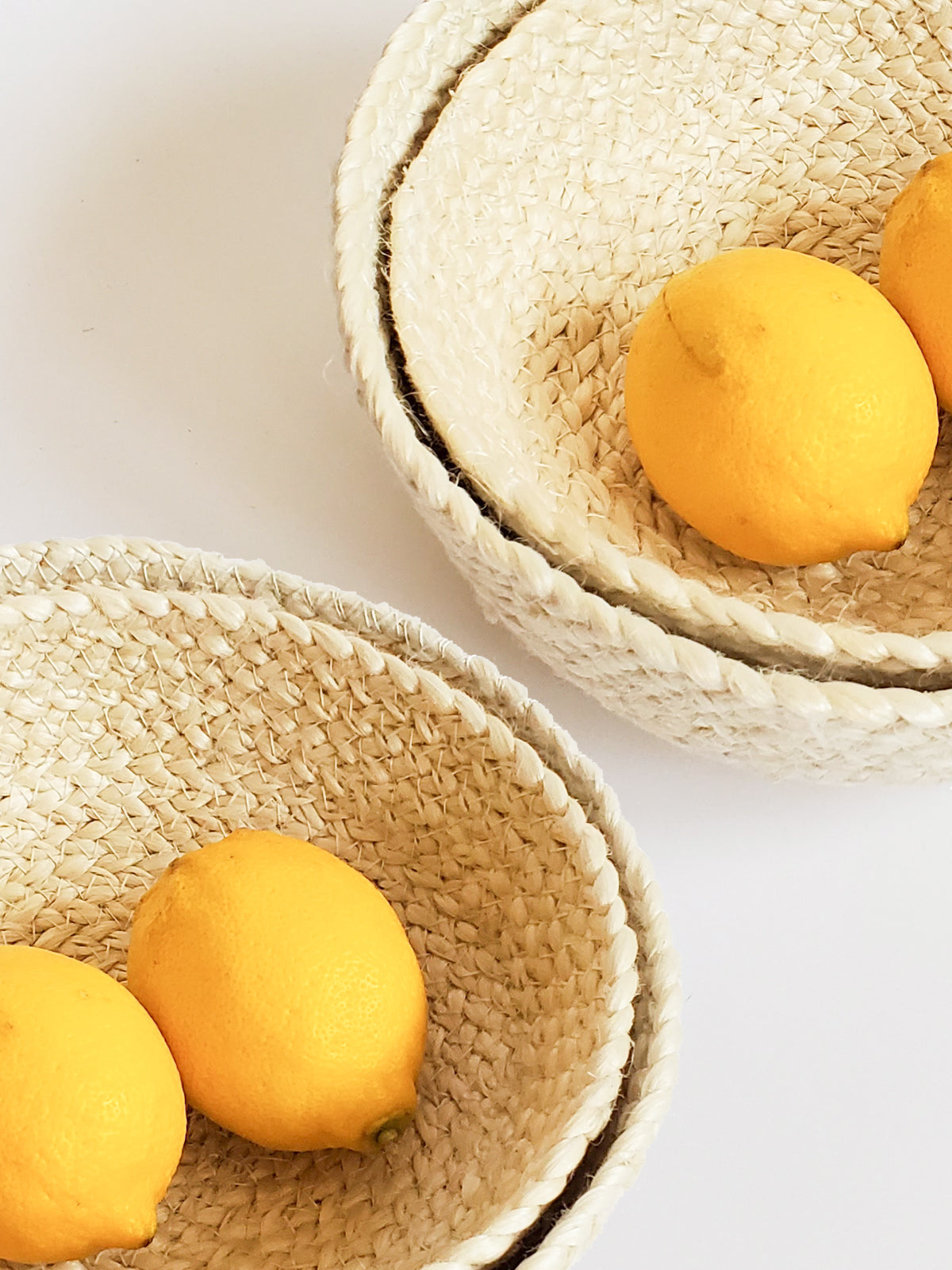 Two woven bowls with lemons on a light background