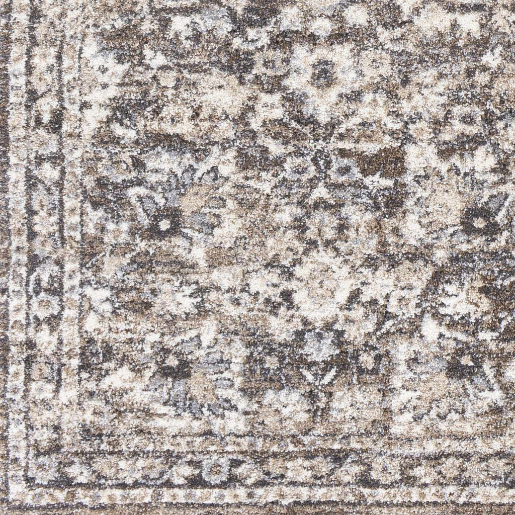 Close-up of a patterned rug with brown, beige, and gray colors.