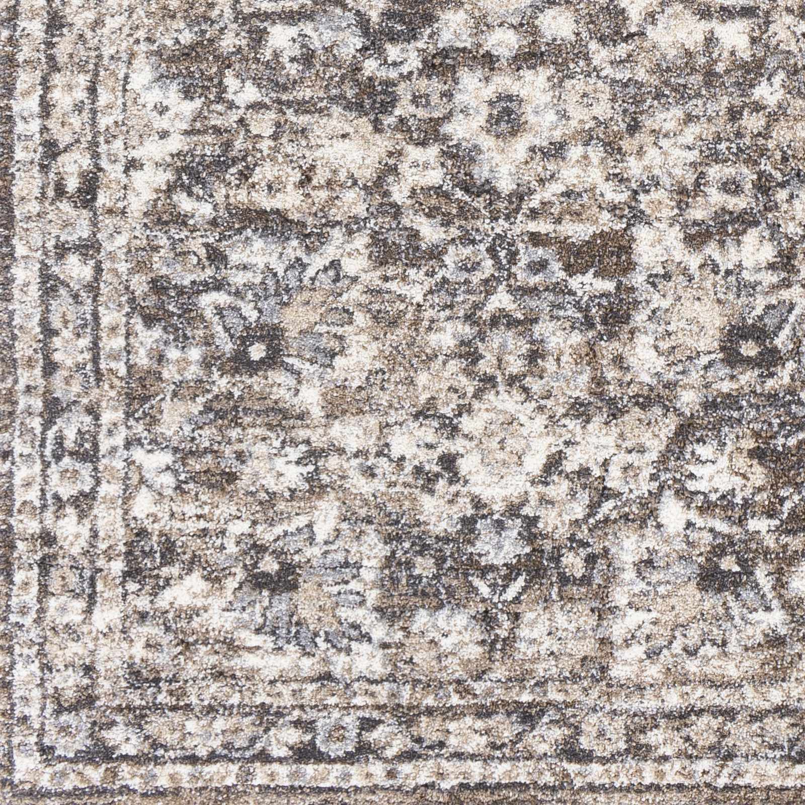 Close-up of a patterned rug with brown, beige, and gray colors.