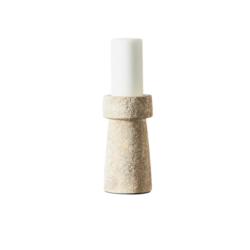 Candle holder with textured base and white candle on a white background