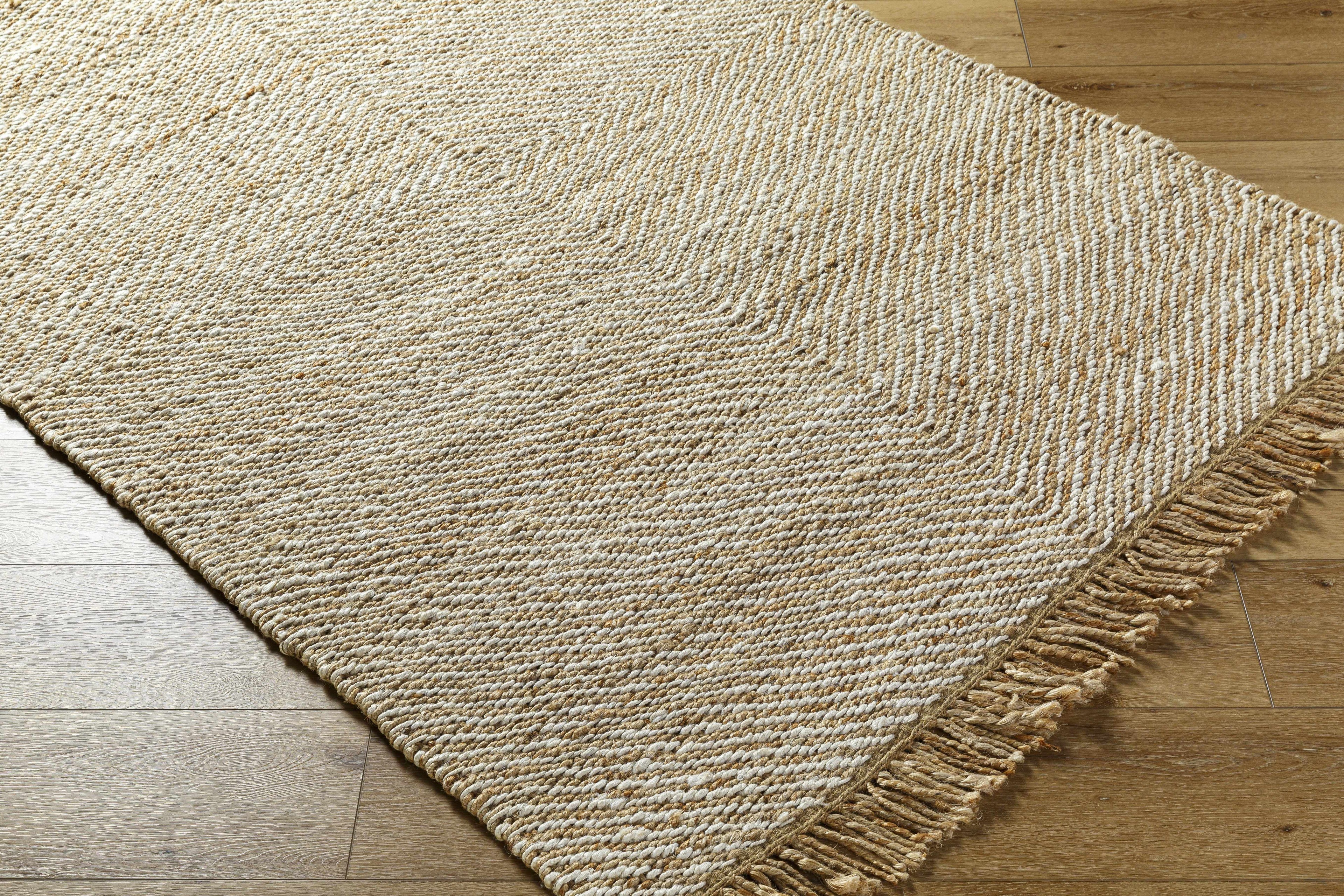 Beige woven rug with a textured pattern on a wooden floor