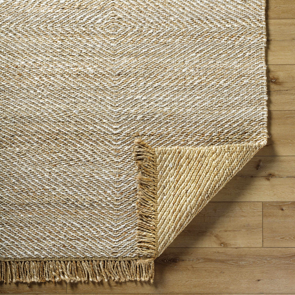 Textured beige rug with fringes on a wooden floor