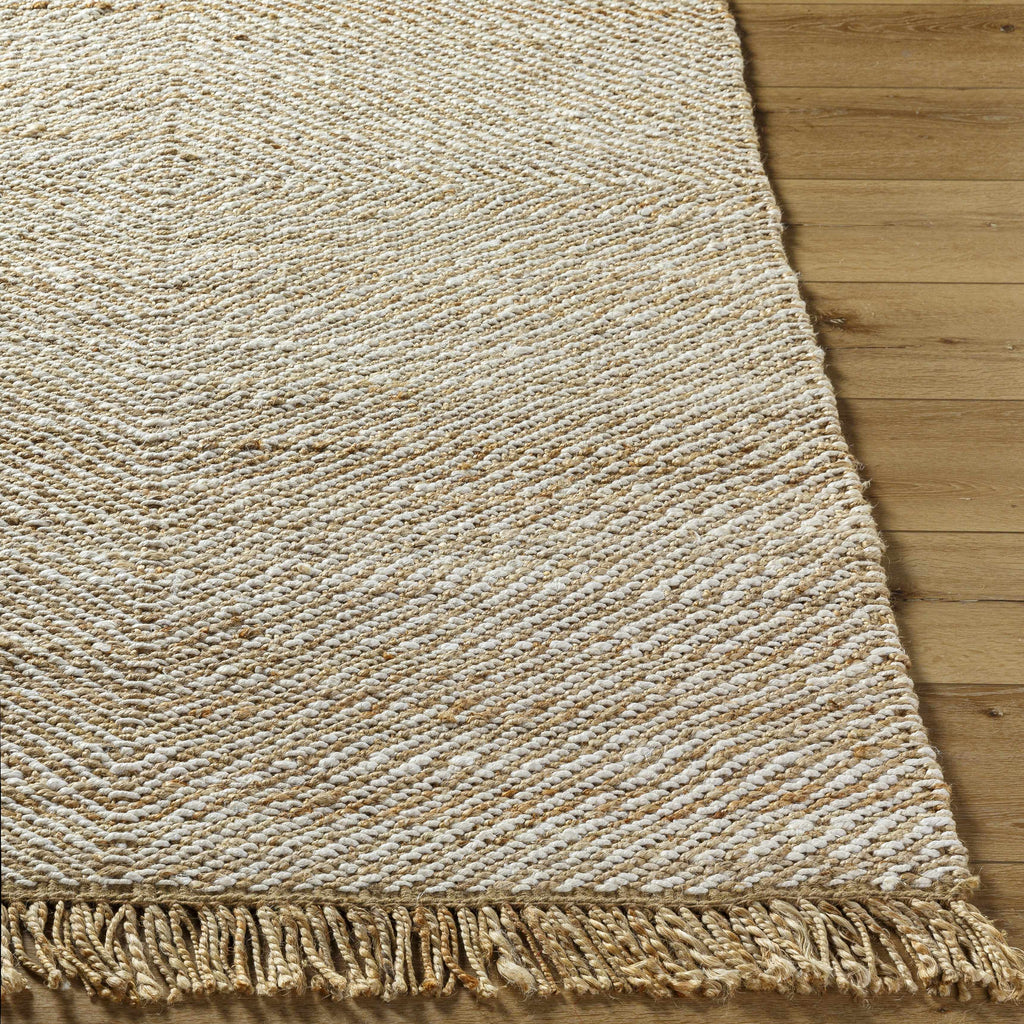 Textured beige rug with fringes on a wooden floor