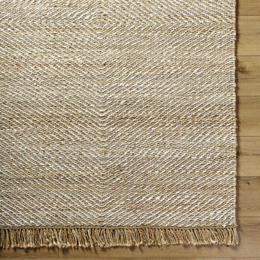 Textured beige rug with fringes on a wooden floor