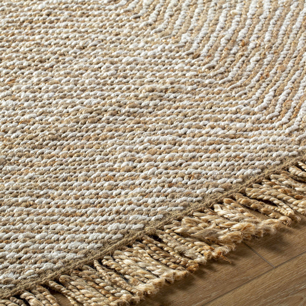 Textured woven rug with fringes on a wooden floor