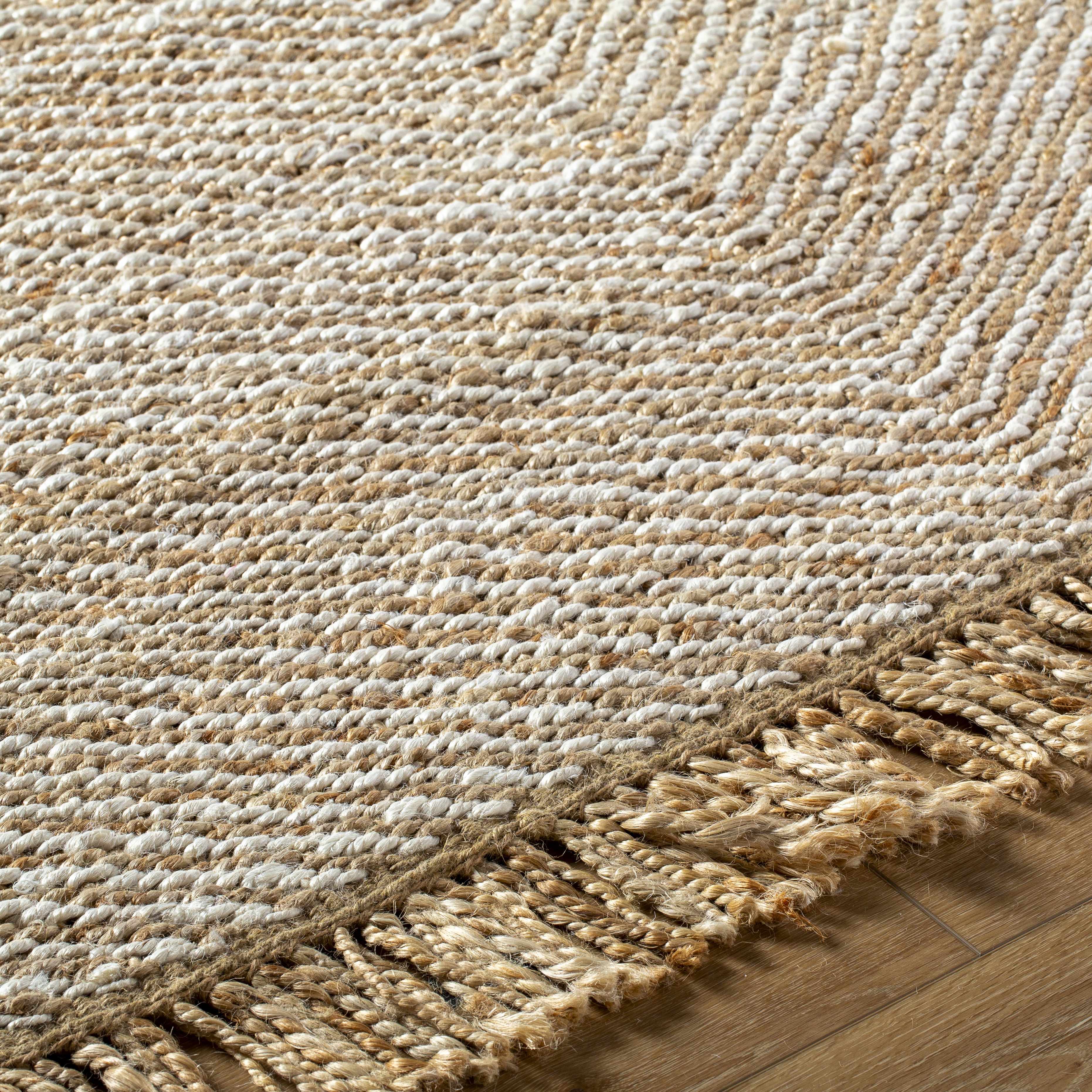 Textured woven rug with fringes on a wooden floor