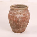 Terracotta jar with a textured surface on a white background