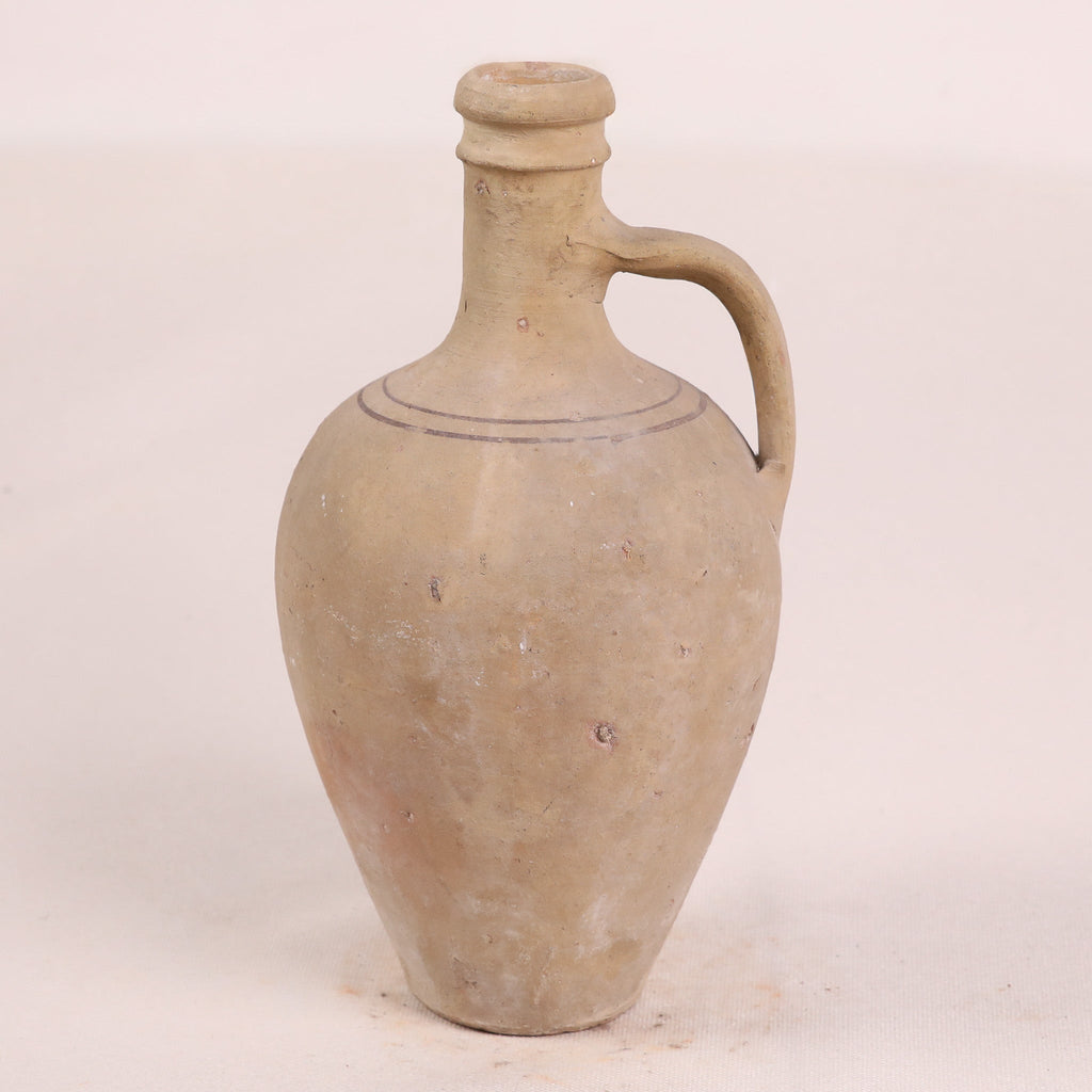 Terracotta jar with a handle on a white background