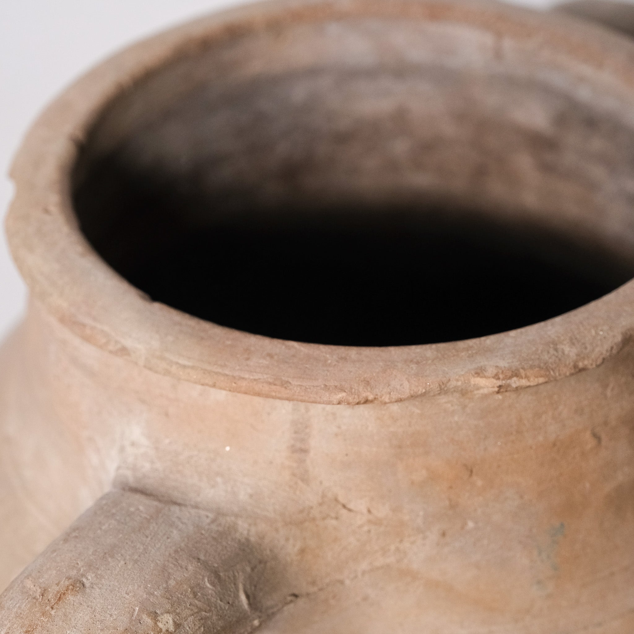 Close-up of a terracotta pot with a dark interior on a white background