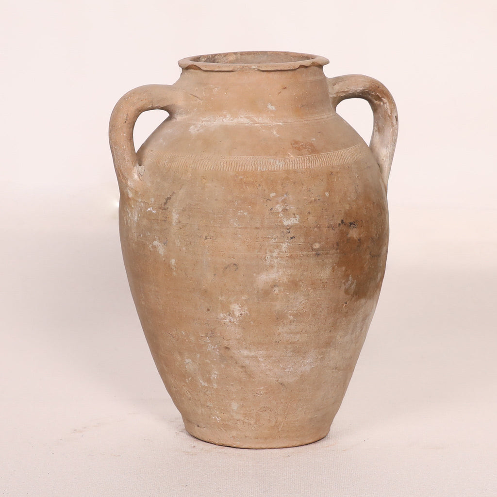 Ancient terracotta jar with handles on a white background