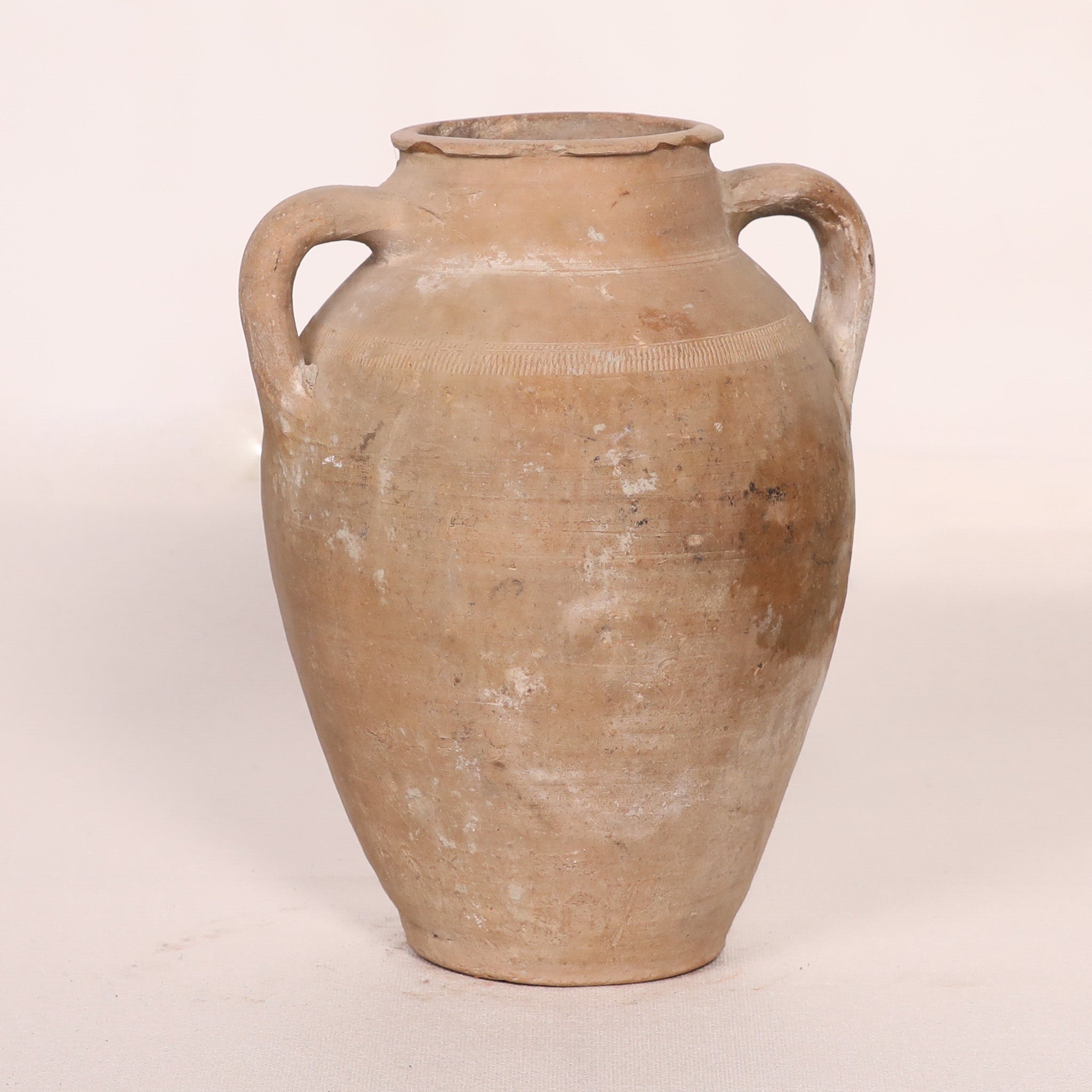 Ancient terracotta jar with handles on a white background