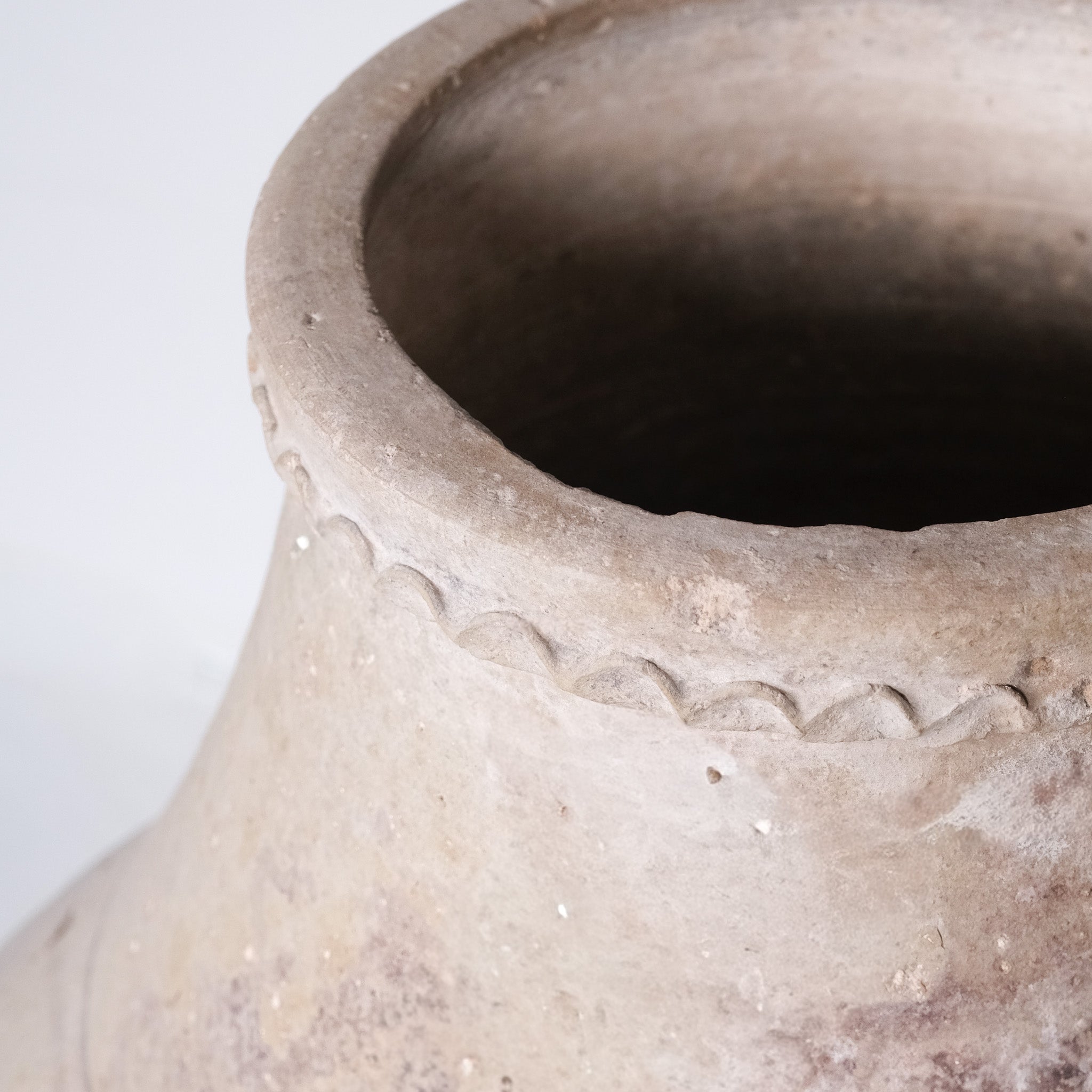 Close-up of a textured clay pot with a white background