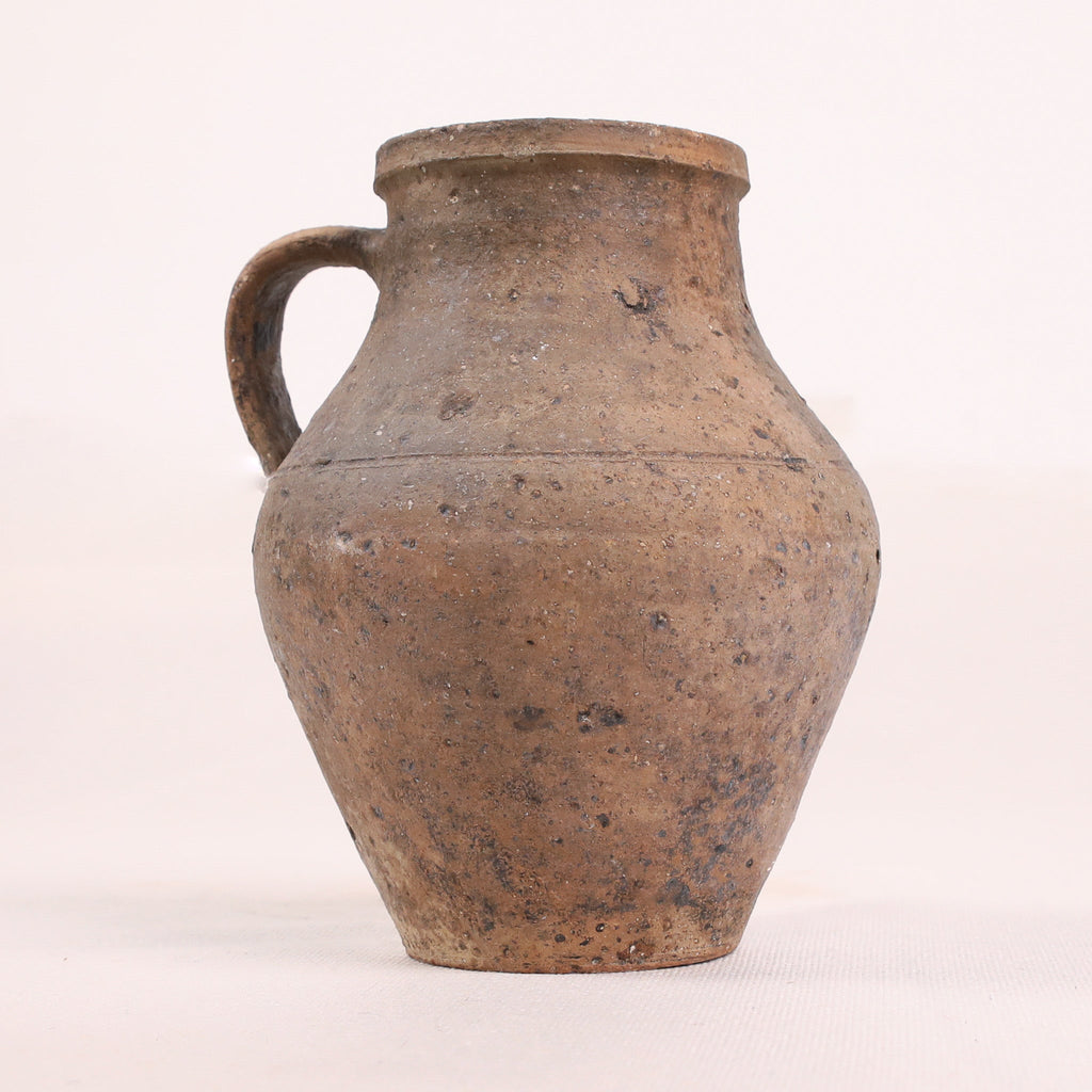 Brown ceramic pitcher on a white background