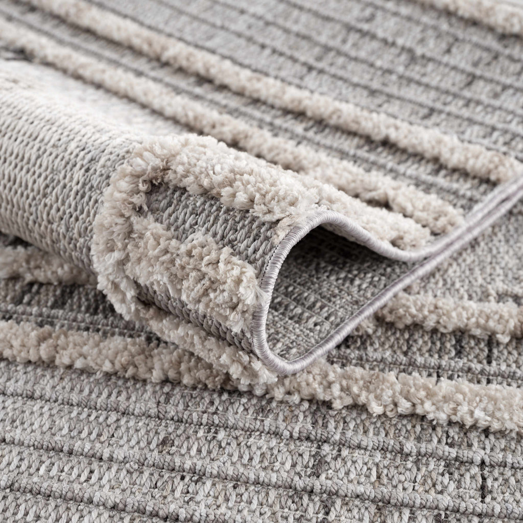 Close-up of a textured gray rug with a folded corner.