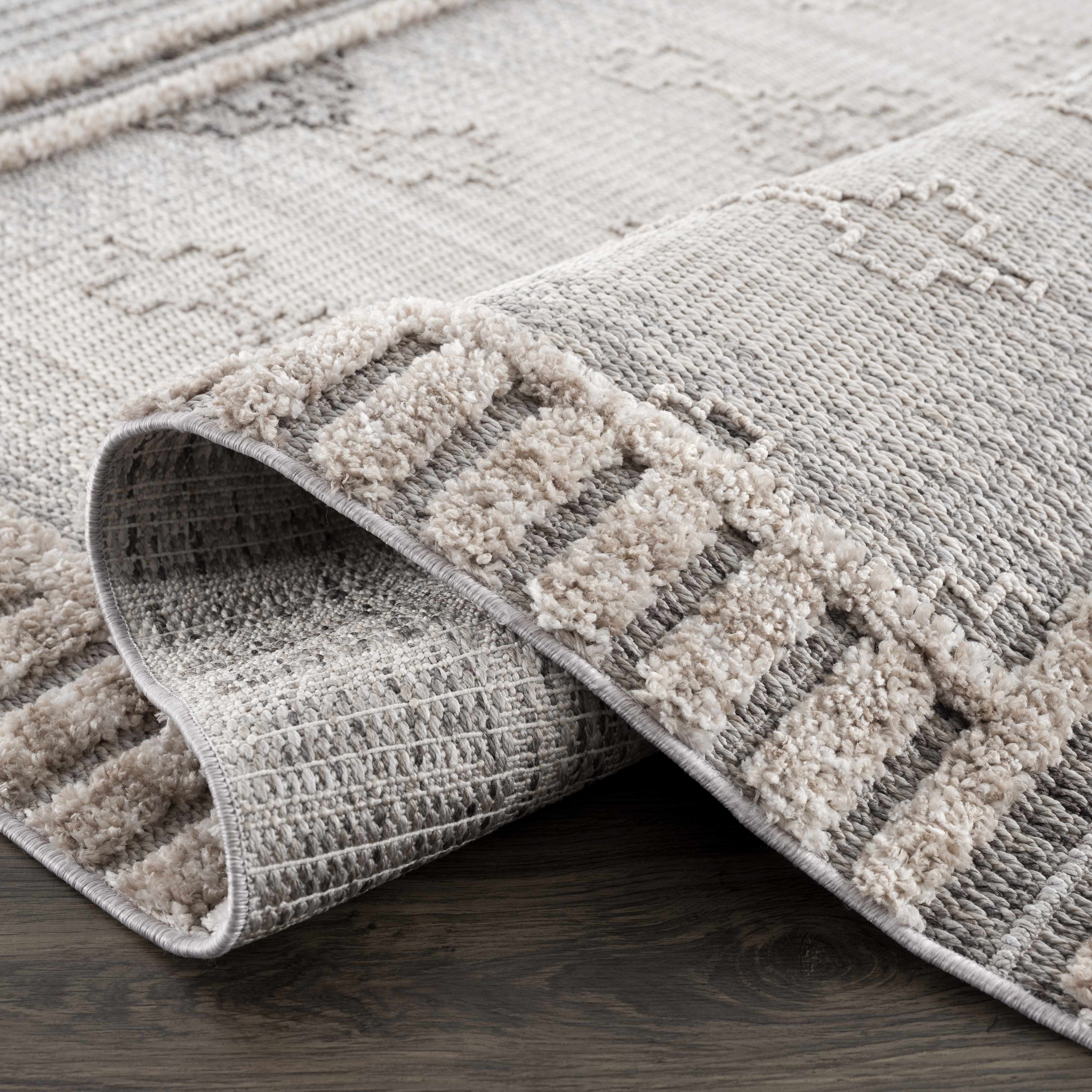 Gray textured area rug on a wooden floor