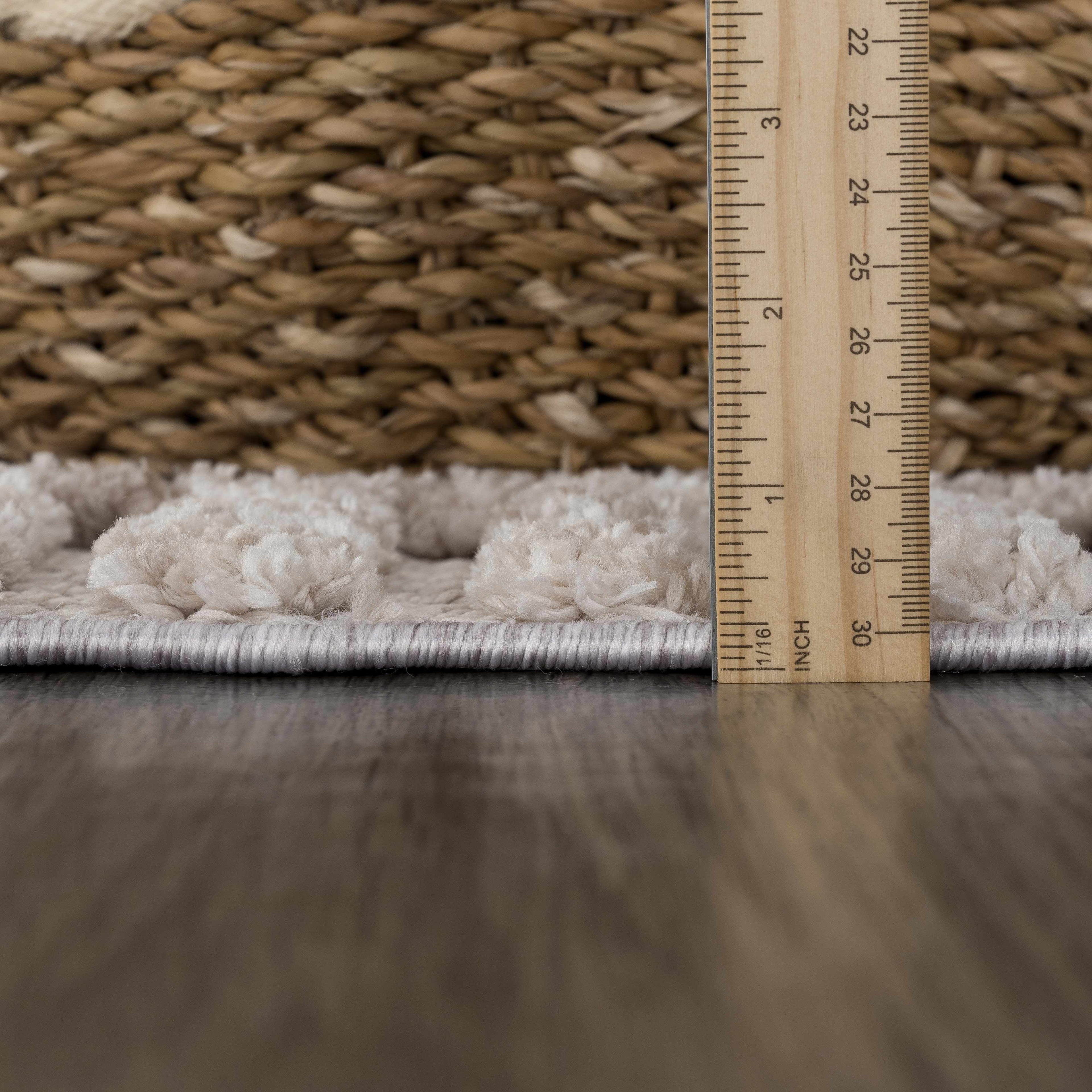 Rug with a wooden ruler showing measurements against a woven rug background