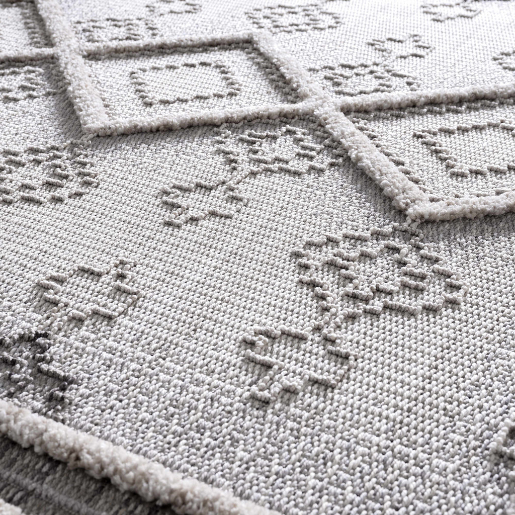 Close-up of a cross-stitched design on fabric with geometric patterns.