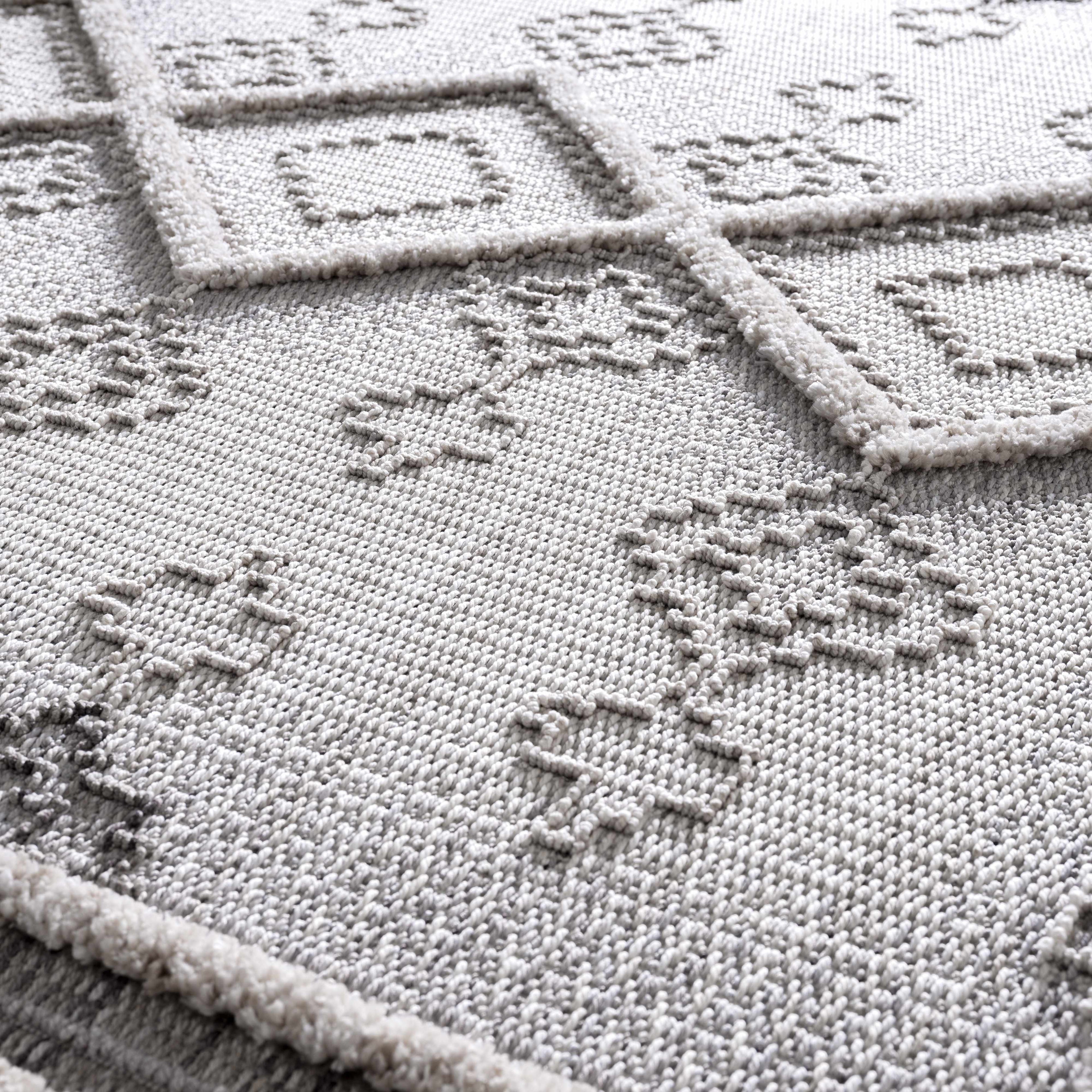 Close-up of a cross-stitched design on fabric with geometric patterns.