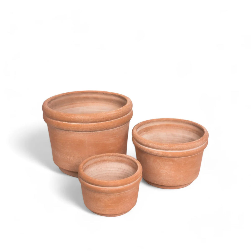 Three terracotta pots of different sizes on a white background