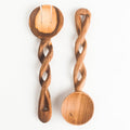Two handcrafted wooden spoons with twisted handles and oval bowls, displayed on a clean white background.