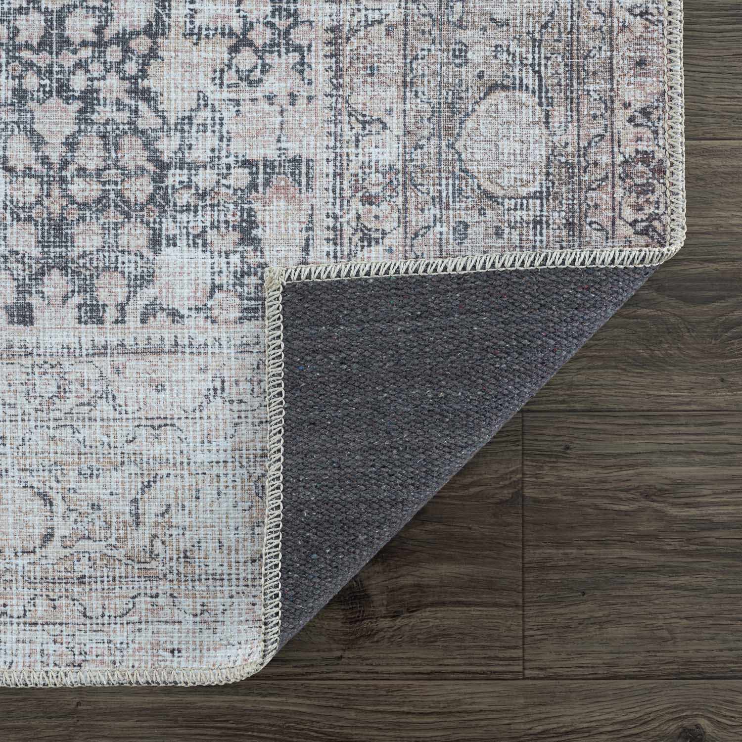 Patterned rug with textured border on a wooden floor
