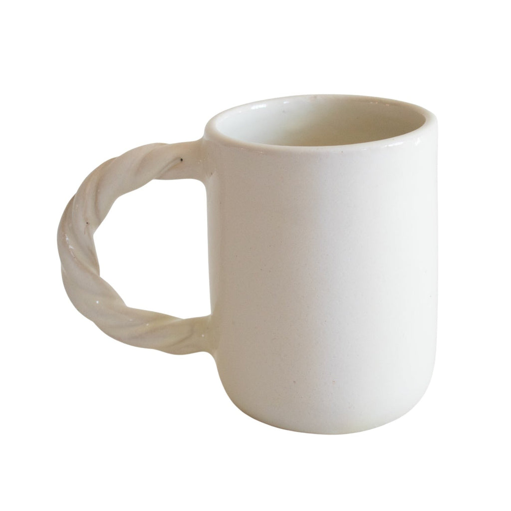 White ceramic mug with a textured handle on a white background