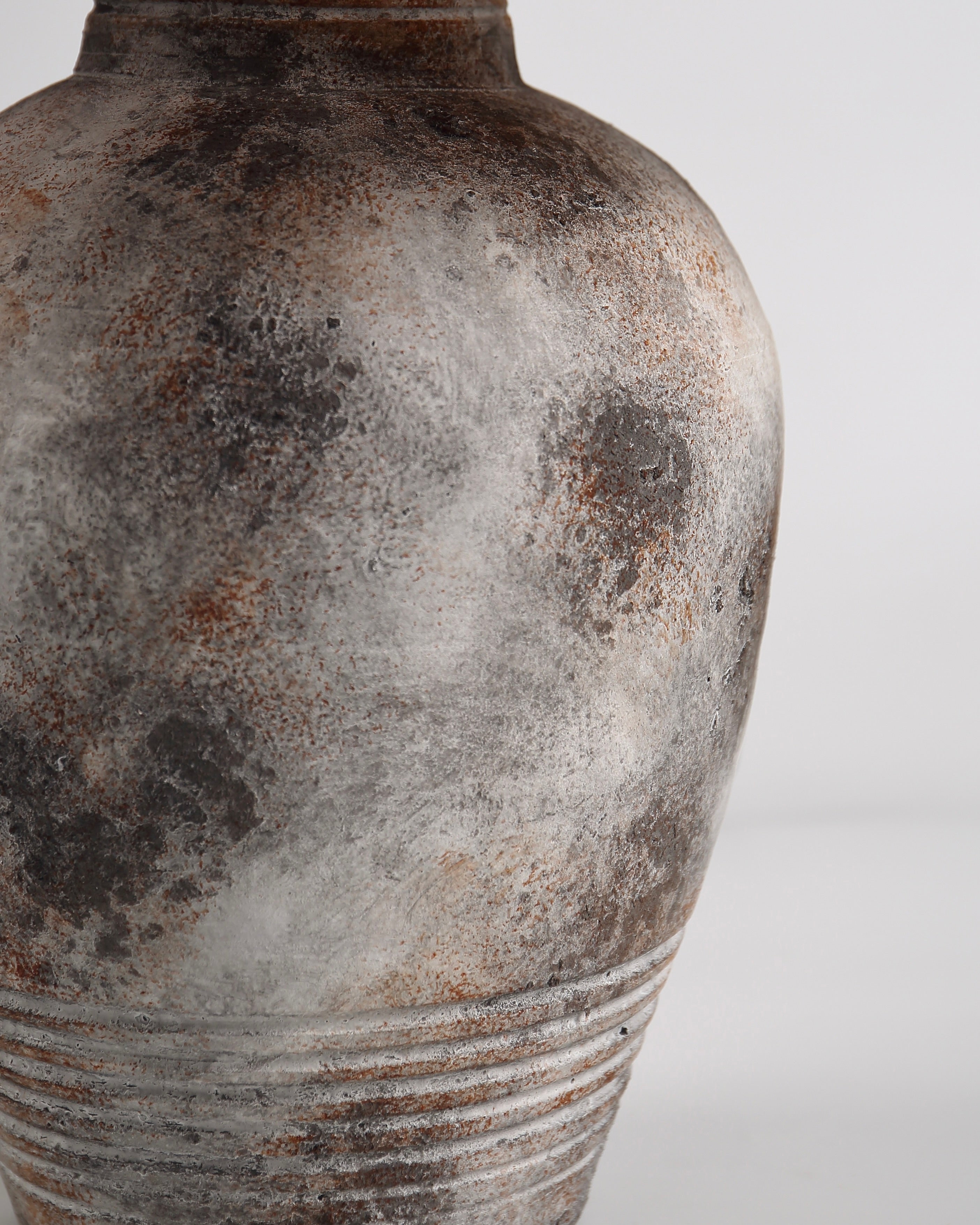Close-up of a textured ceramic vase on a light gray background