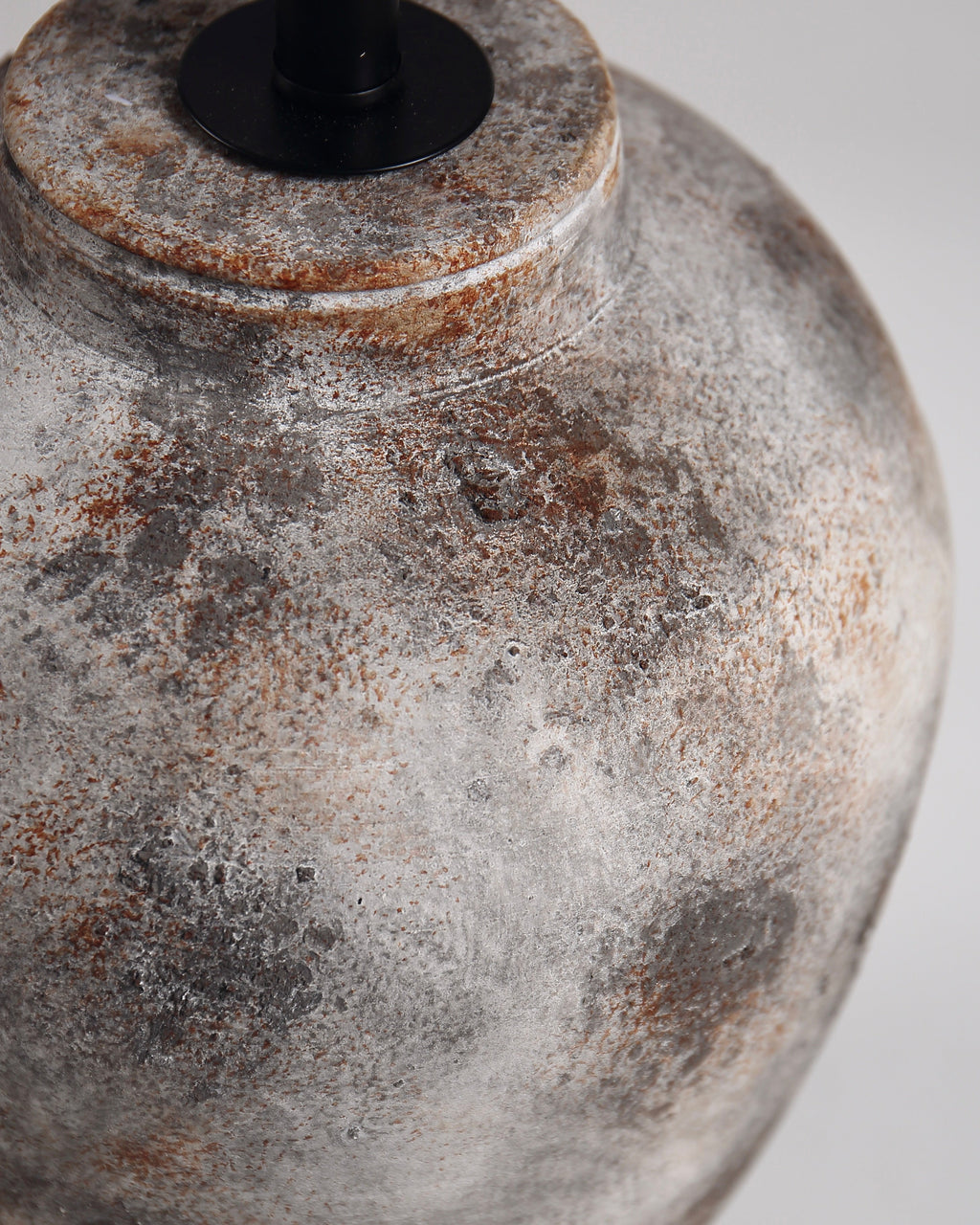 Close-up of a textured ceramic vase with a rustic finish on a white background