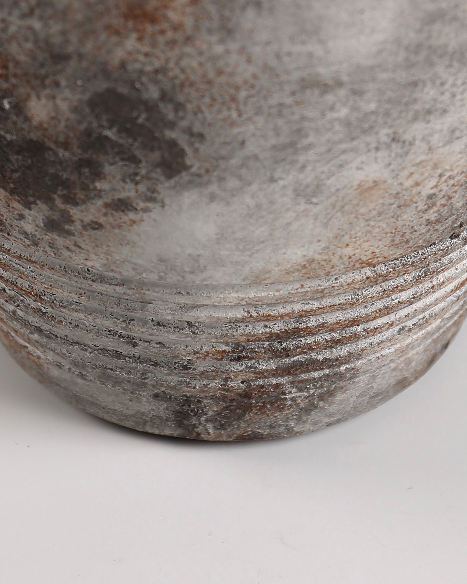 Close-up of a stone bowl with natural patterns and textures on a white background