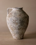 Vintage ceramic vase with a textured surface on a beige background