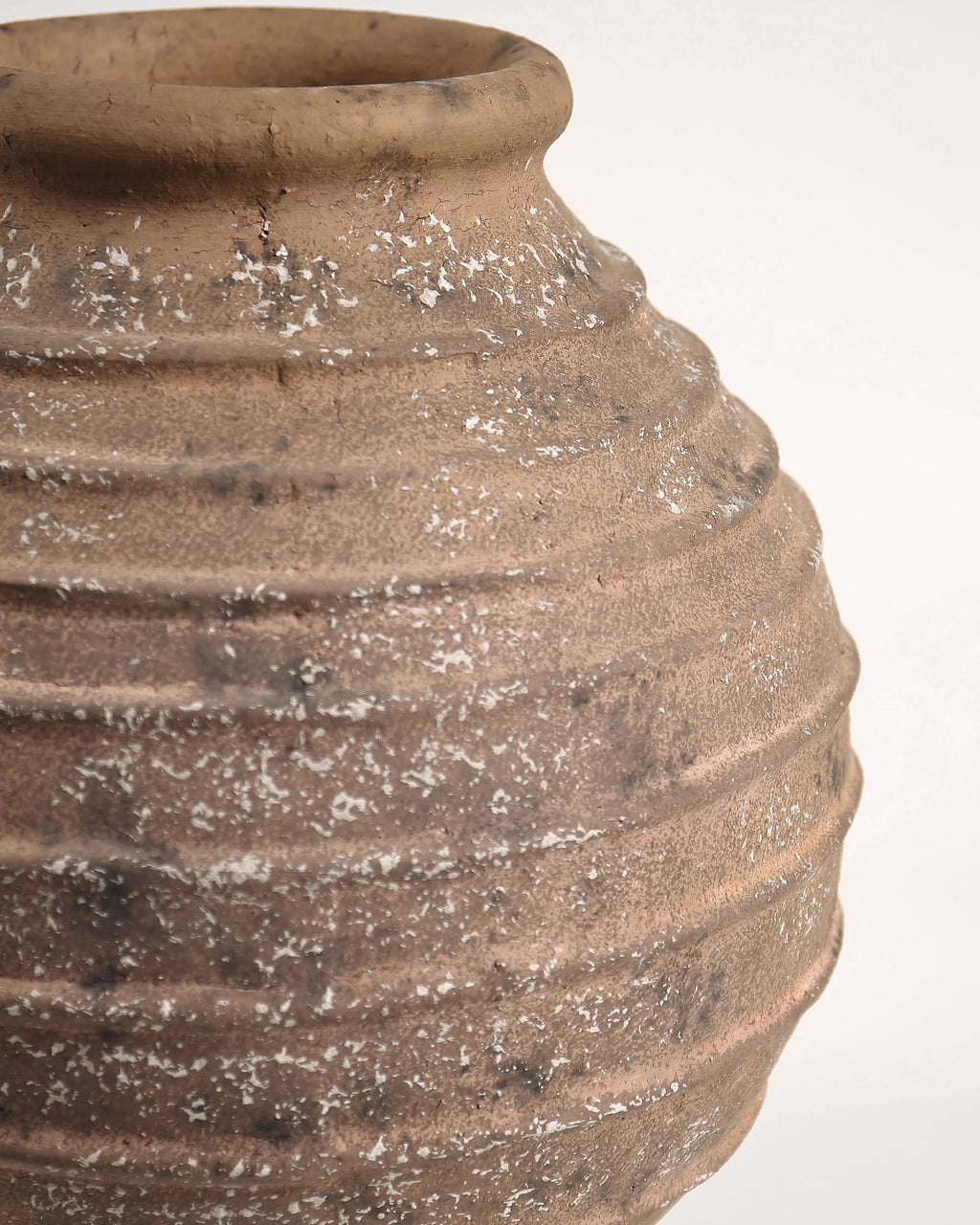 Close-up of a textured brown ceramic vase on a white background