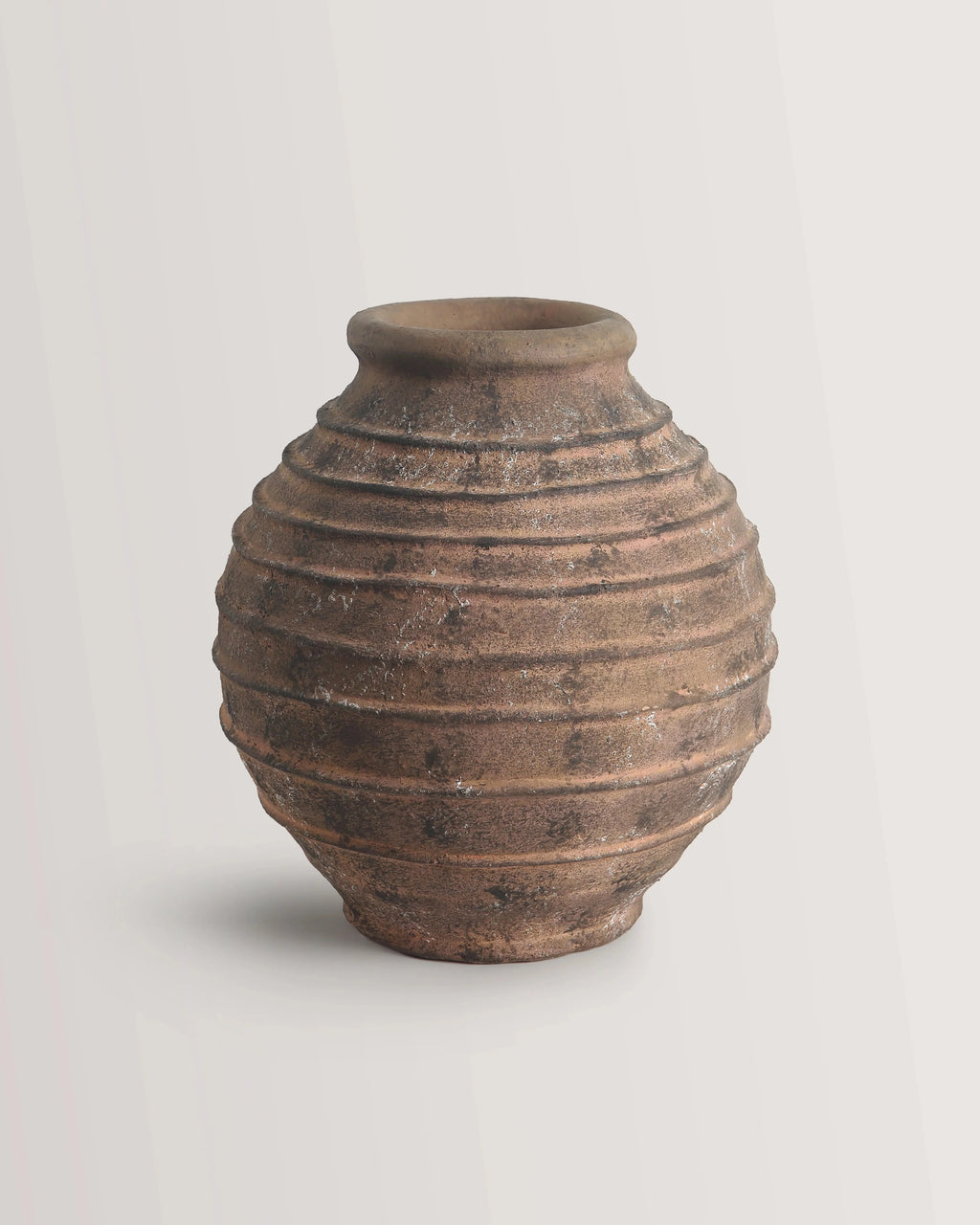 Brown ceramic vase with textured surface on a light gray background