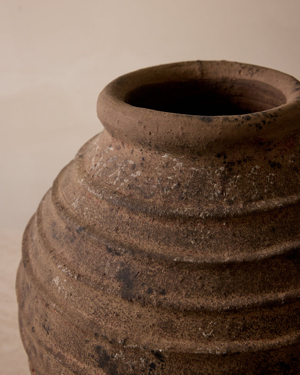 Close-up of a brown ceramic pot with a beige background