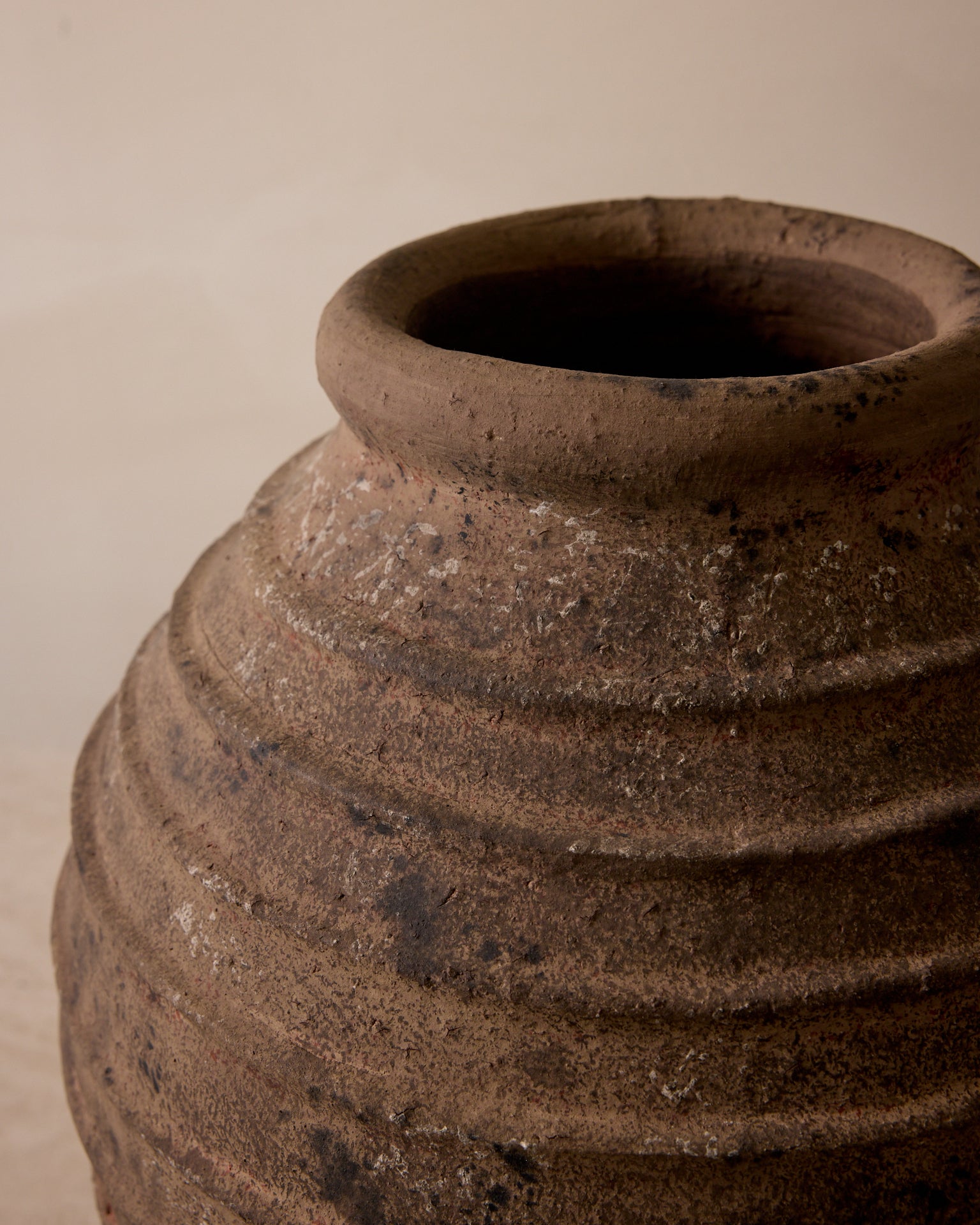 Close-up of a brown ceramic pot with a beige background