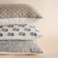 Three patterned pillows stacked on a beige background