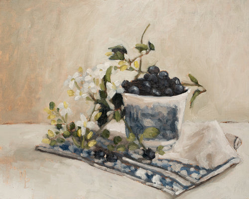 Blueberries in a teacup fine art print featuring ripe blueberries gathered in a delicate teacup alongside white blossoms and a patterned textile. Soft neutral tones, painterly brushstrokes, and classic still life composition create timeless wall art for kitchens, dining rooms, and European-inspired interiors.