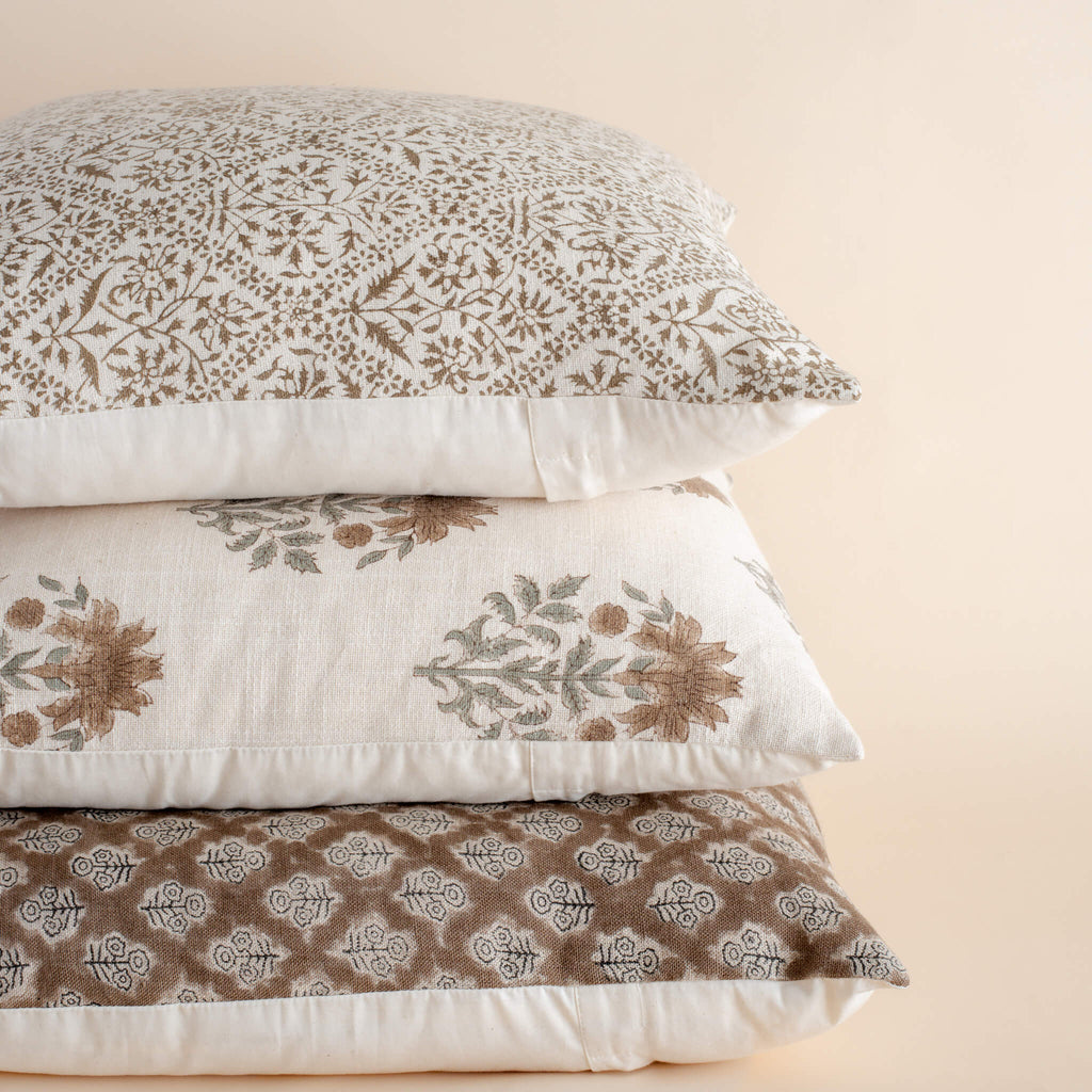 Stack of patterned pillows on a beige background