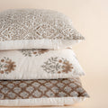 Stack of patterned pillows on a beige background