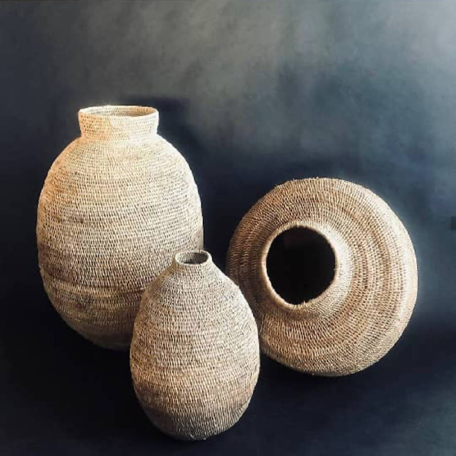 Three woven vases of different shapes on a dark background