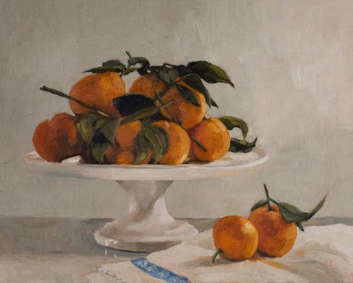 Clementines on pedestal bowl fine art print featuring vibrant orange clementines with leafy stems arranged on a classic cake stand. Soft natural light, warm tones, and painterly brushstrokes create timeless still life wall art for kitchens, dining rooms, and European-inspired interiors.